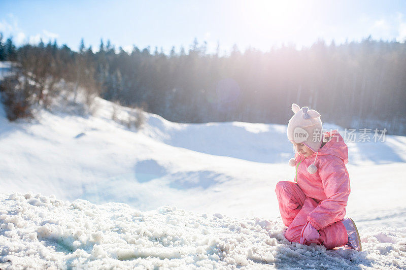 孩子坐在雪地里