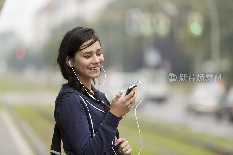 年轻女子通过耳机欣赏音乐