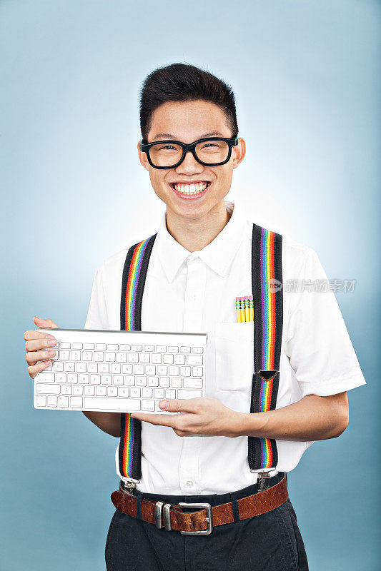 亚洲书呆子男孩拿着无线键盘