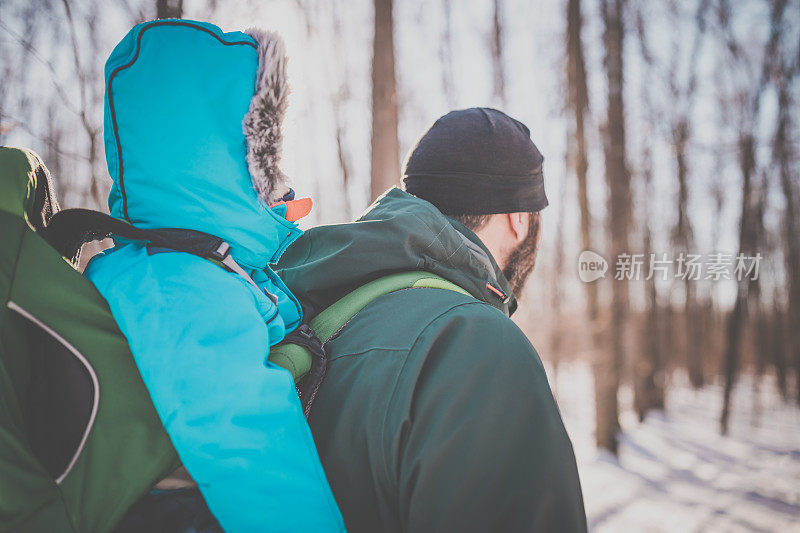 父亲和宝宝在冬季森林徒步旅行