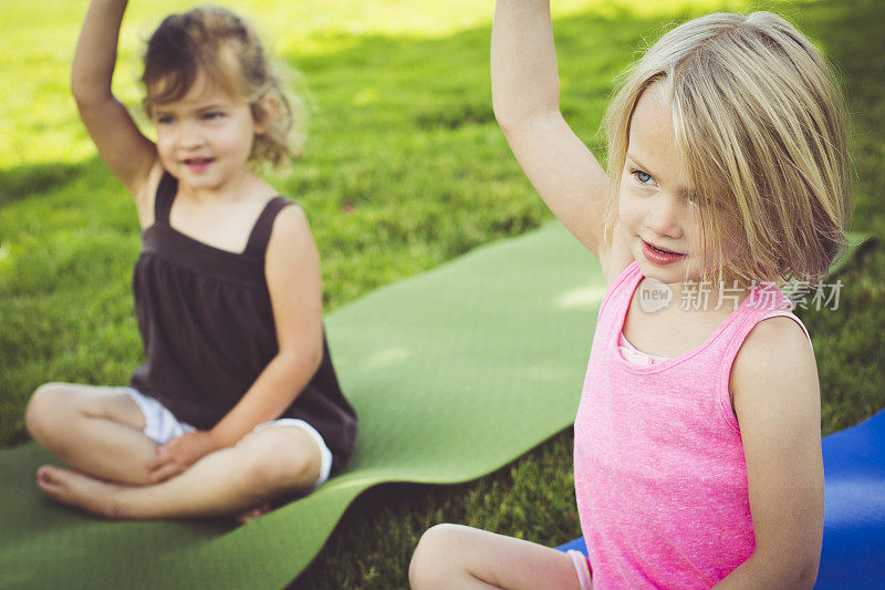 小女孩们在公园里做瑜伽。