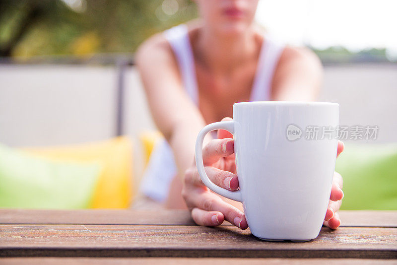 女性手拿咖啡杯的照片