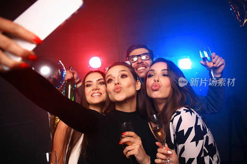 派对，科技，夜生活和人的概念-微笑的朋友与智能手机在俱乐部自拍。