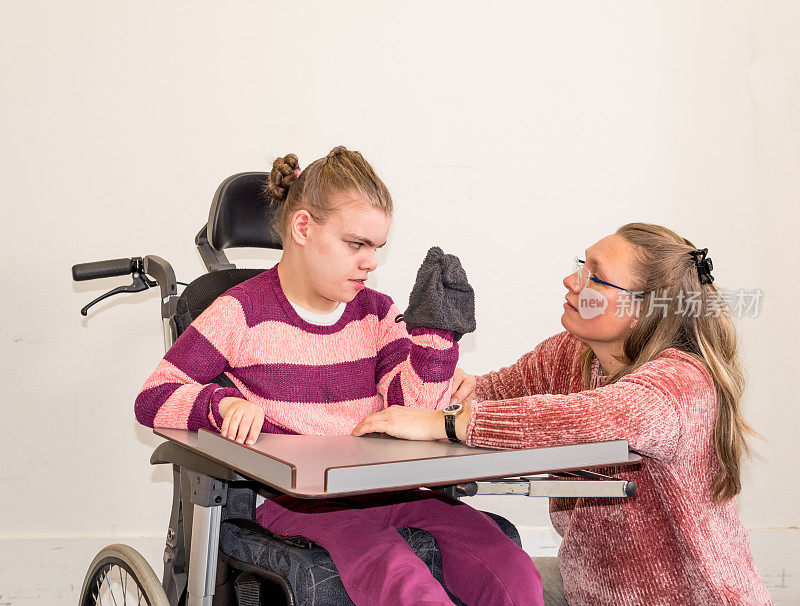 一名坐在轮椅上的残疾儿童和一名志愿护理人员在一起