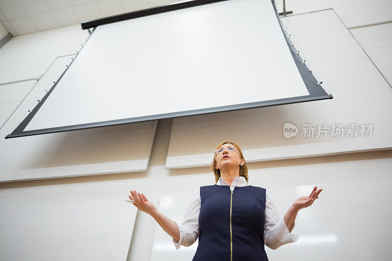 女教师用投影屏幕在报告厅