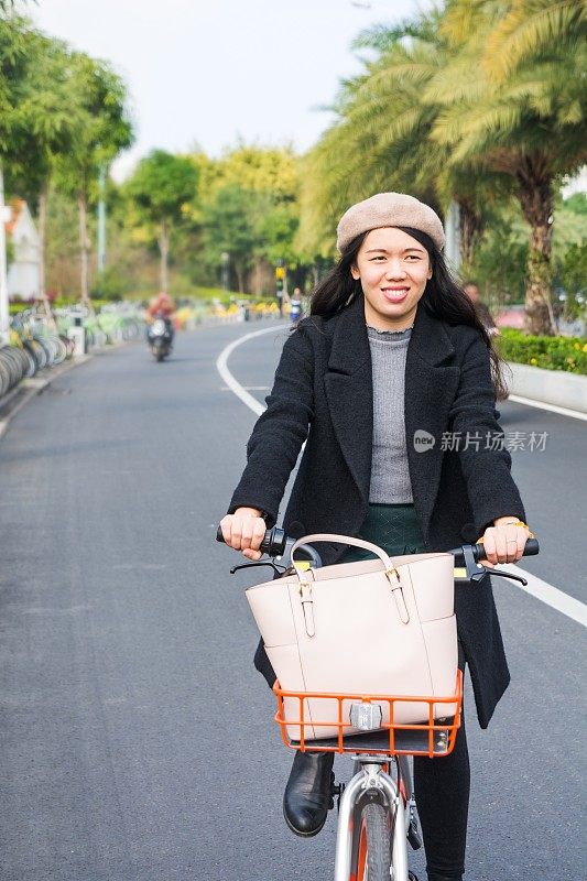 亚洲办公室女士骑自行车穿过市区