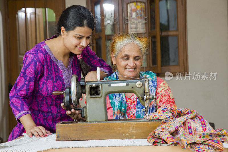 母亲和女儿缝纫库存图像