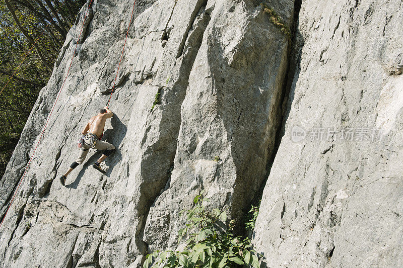一个人安全地爬着岩壁