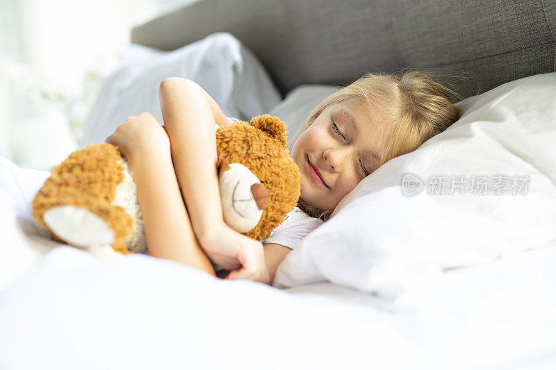 一个小女孩在床上睡觉，梦见泰迪熊，