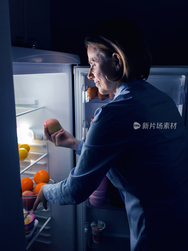 在冰箱里看食物的女人