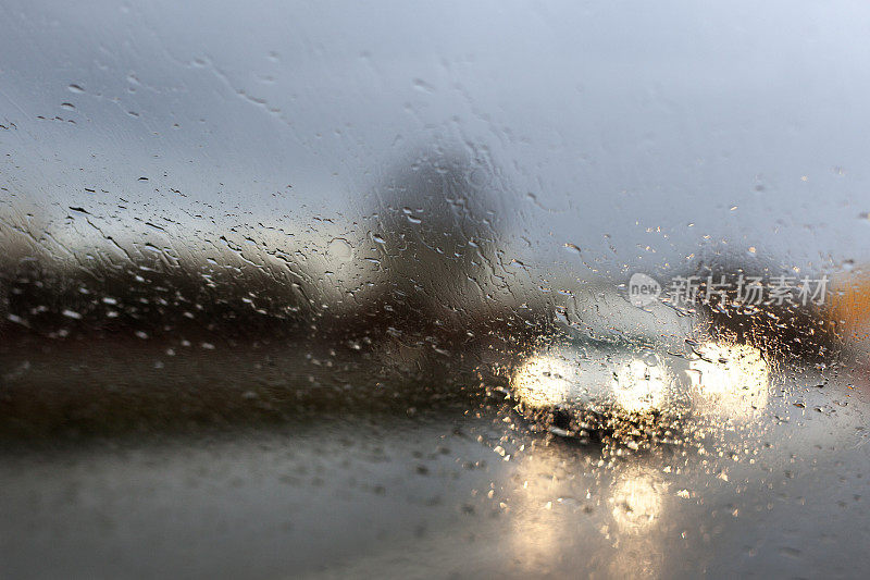 下着雨的马路，透过挡风玻璃看，车水马龙