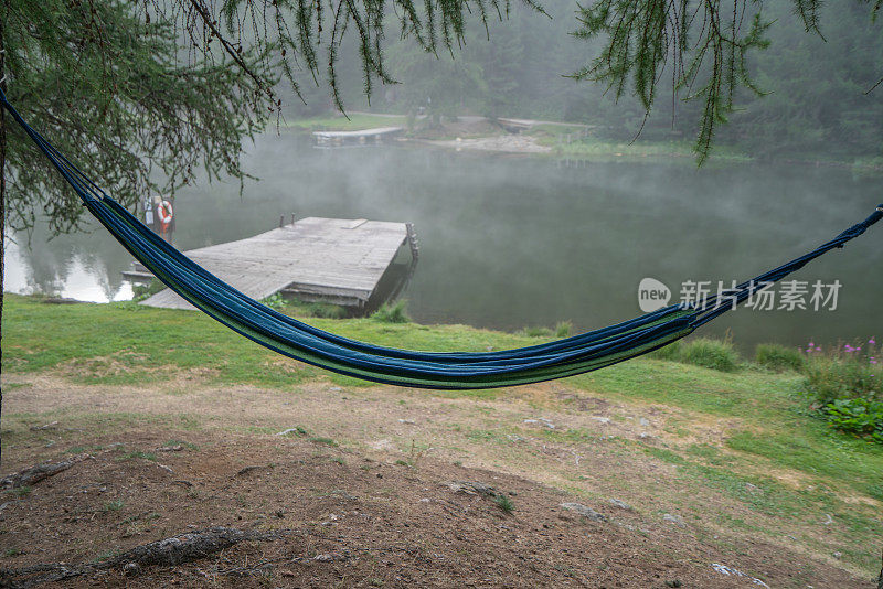 吊床挂在山湖附近的树上