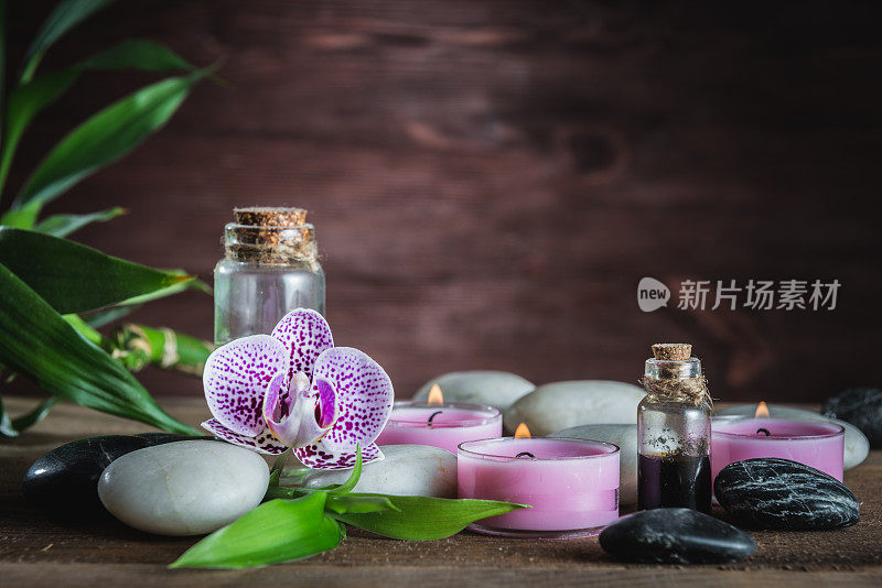 白色禅宗平衡石，兰花和竹植物在木桌上