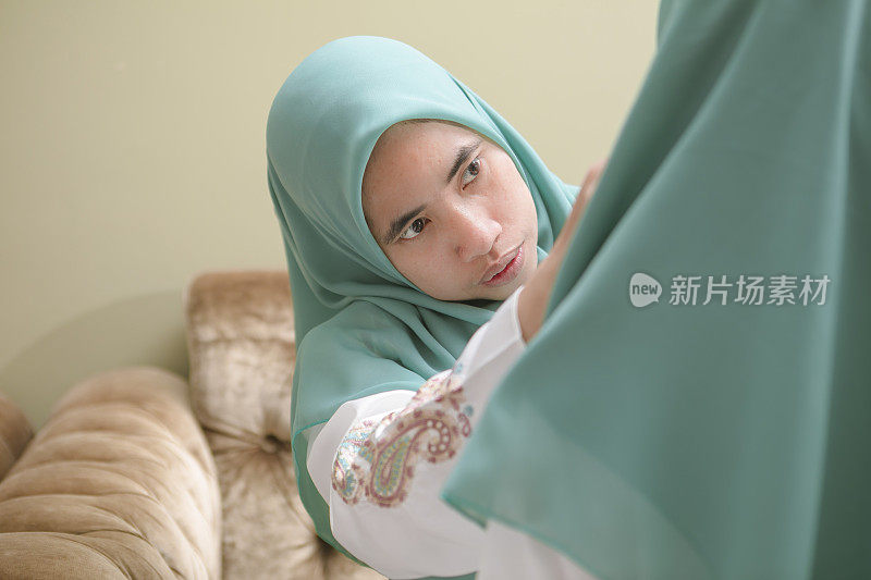 一个穆斯林母亲戴着她女儿的头巾庆祝开斋节
