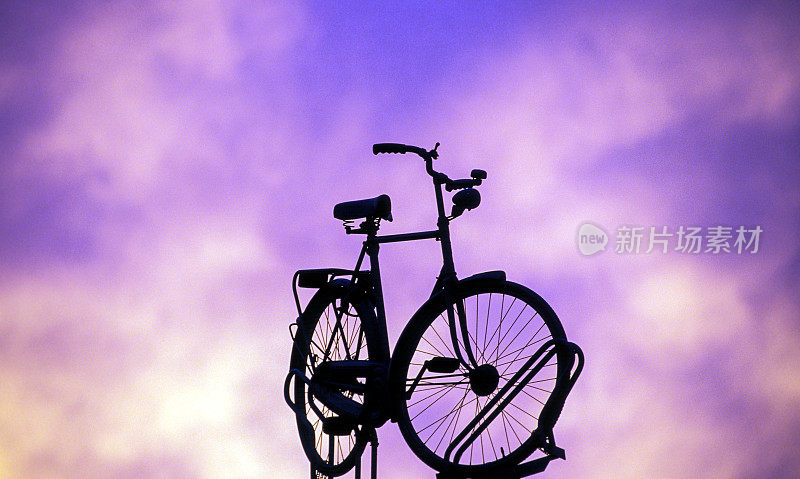 一辆自行车的剪影在美丽的日落背景
