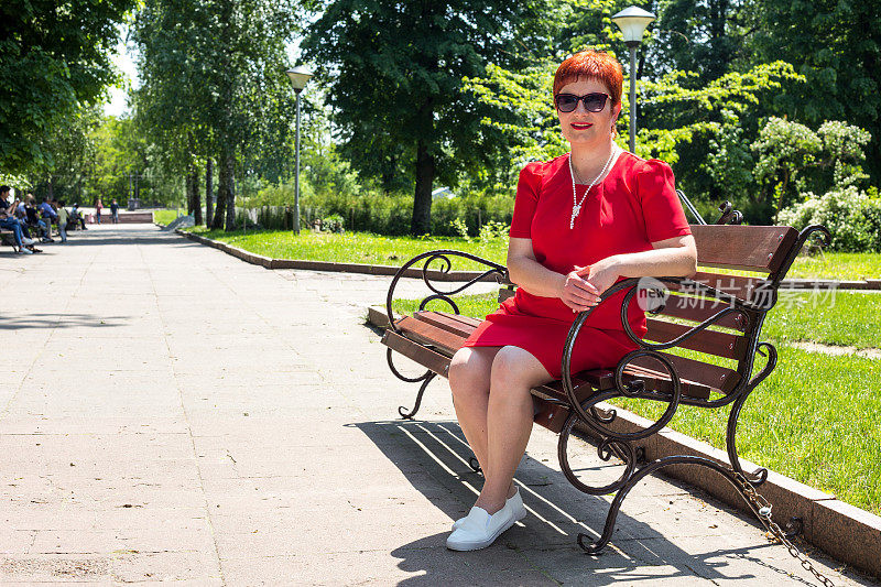 一个女人坐在公园的长椅上。