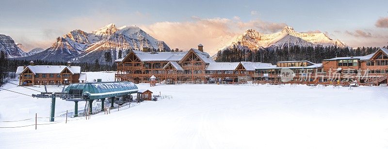 视野横跨冰冻的湖泊和积雪覆盖的建筑物和山脉