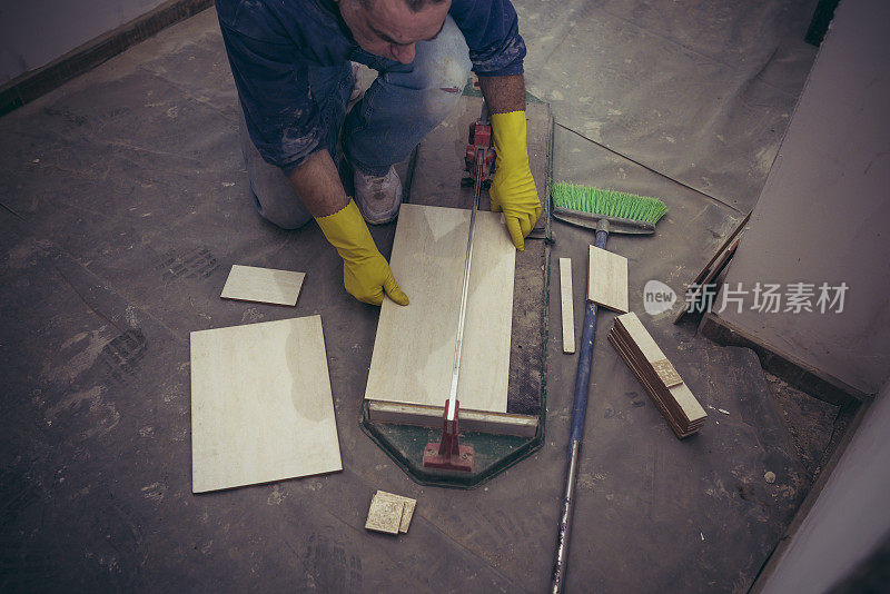 工人在测量和切割瓷砖的照片