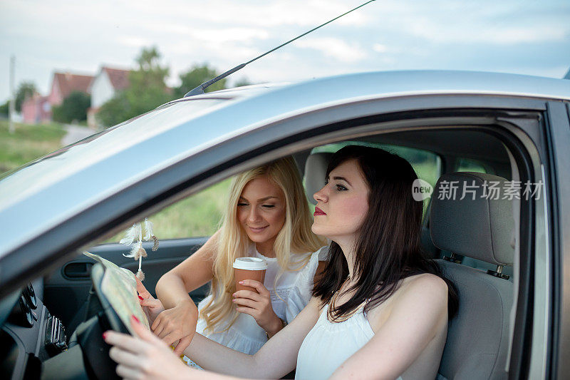 年轻女子正在开车，一边看地图。