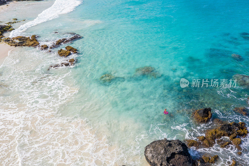 无人机的女人放松在海上与充气戒指