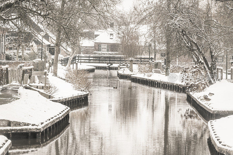 在一个寒冷但美丽而平静的冬天，Giethoorn村附近的Dwarsgracht有积雪的运河