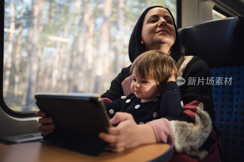 一位年轻的母亲带着她可爱的女儿乘火车旅行