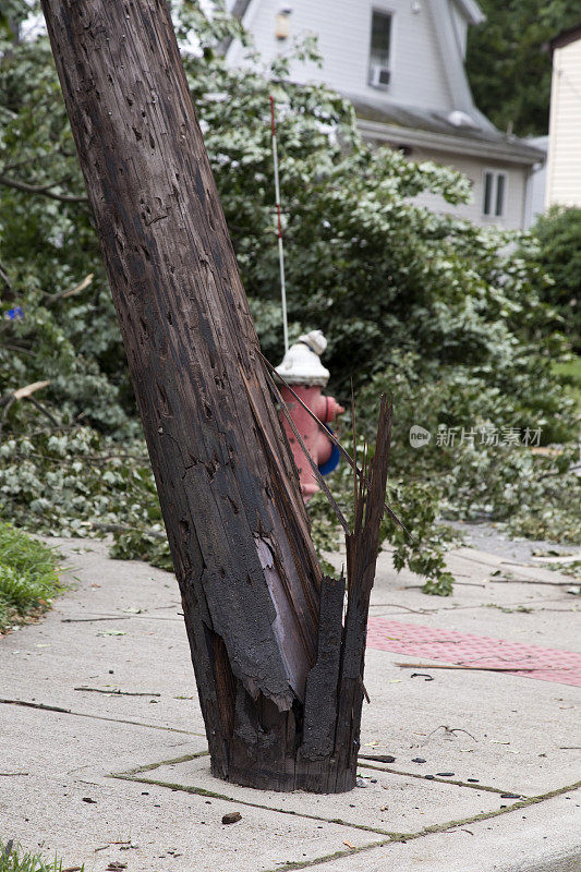 一场暴风雨过后，居民区街道上被损坏和劈裂的电线杆