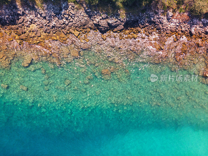 鸟瞰图美丽的海滩上的希腊岛，岩石海岸与绿松石海
