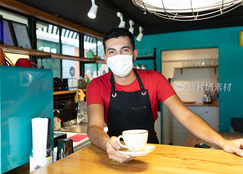 在咖啡店工作的年轻人戴着面具给咖啡杯