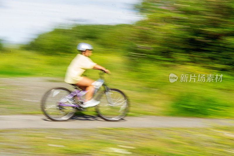 12岁的女孩在乡下骑自行车