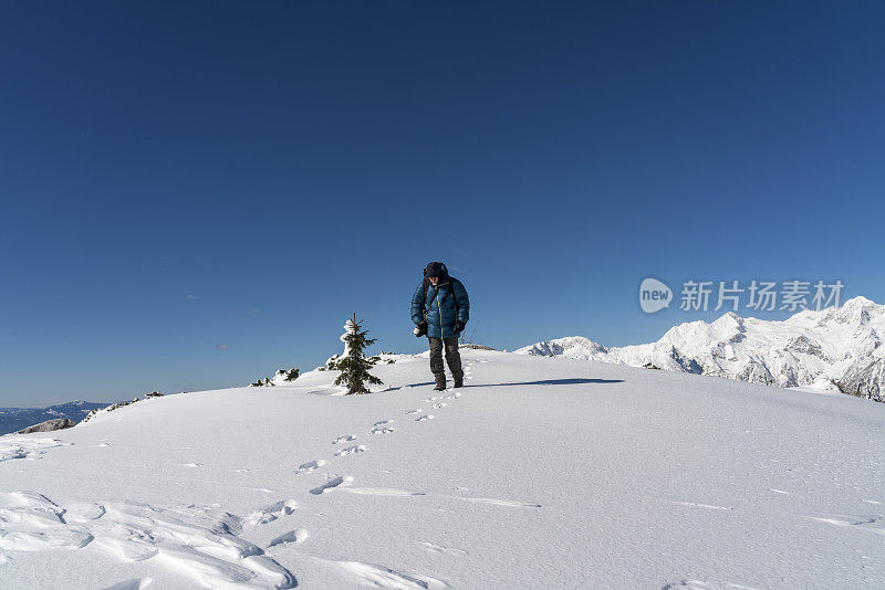 人们在蓝天的映衬下从雪山上走下来