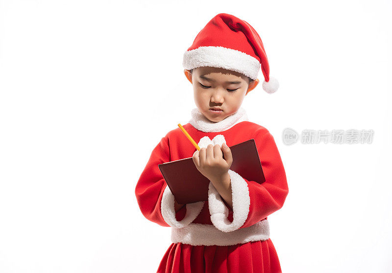 圣诞女孩在白色背景的笔记本上写下愿望清单