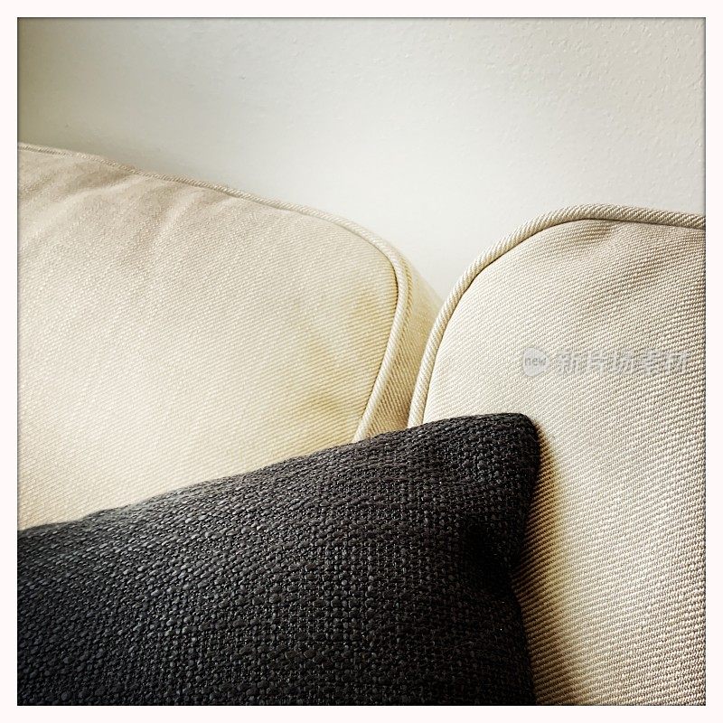 米色沙发上的黑色枕头