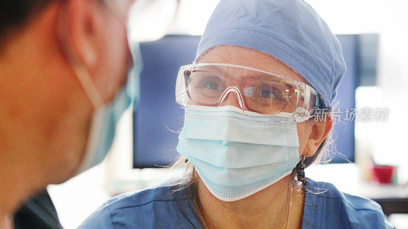女卫生工作者微笑后的病毒防护装备，与病人讨论