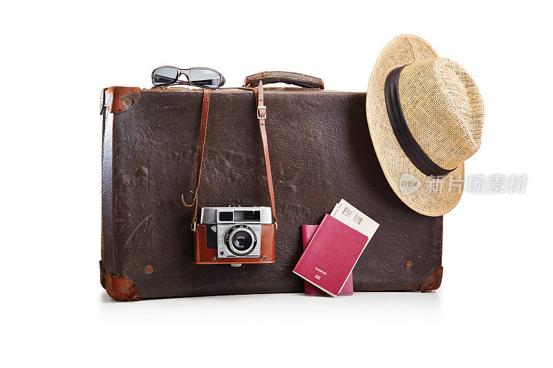 老式的老式棕色皮箱，配有一个胶卷照相机，一顶草帽和两本印有白色机票的护照