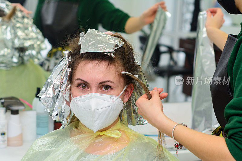 一个女人在理发店里染发，用箔纸染发。