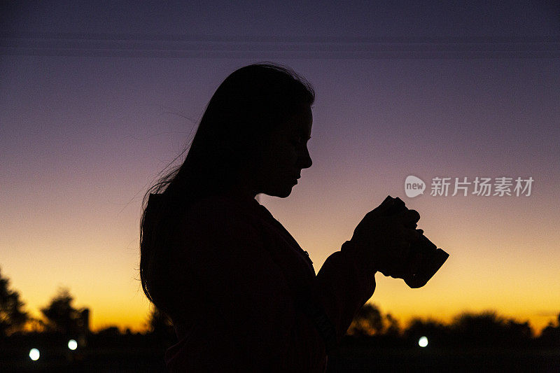 拉丁妇女在度假拍摄日落在山区。