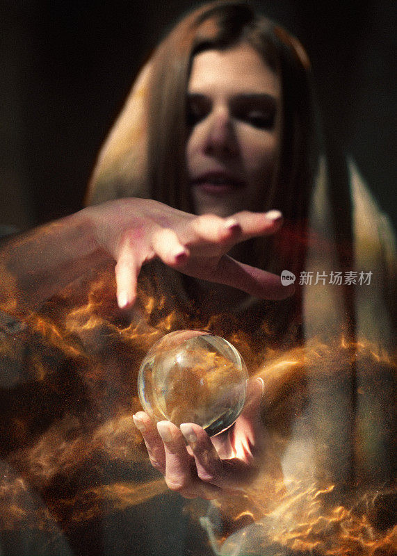 妩媚的算命女拿着玻璃球，里面有魔法，发光的灰尘