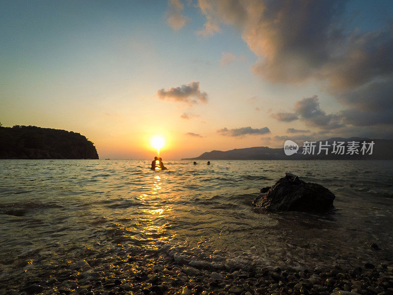 在美丽的夕阳下，海上有一对佳酿情侣