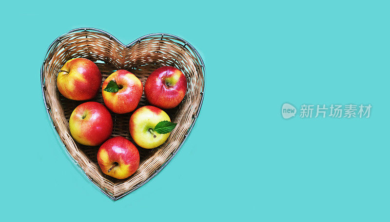 红苹果装在蓝底心形竹篮里。宗教节日概念——犹太新年或犹太新年。