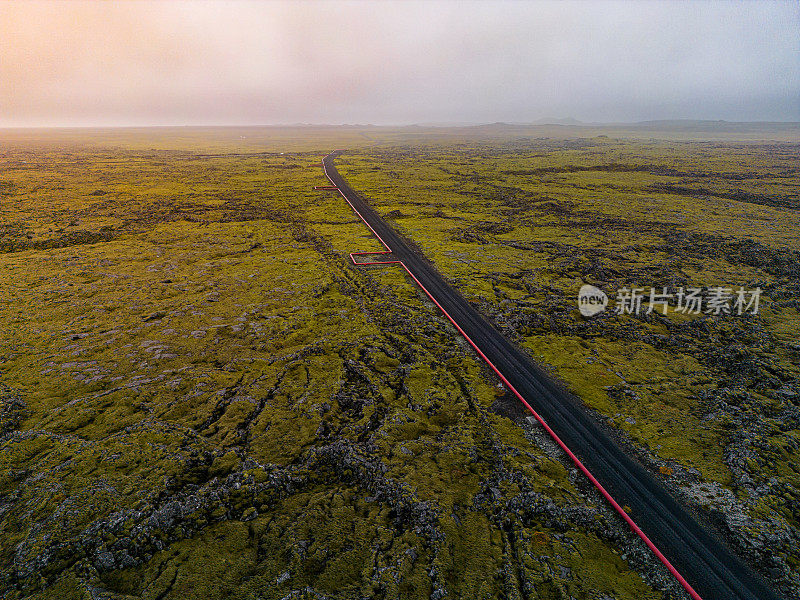 冰岛火山景观中通往发电厂的地热红管