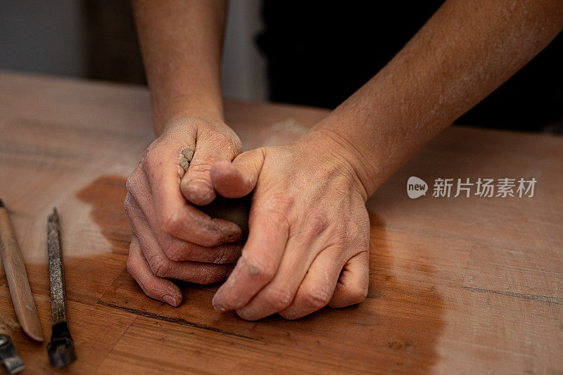 女人用手揉着一块粘土