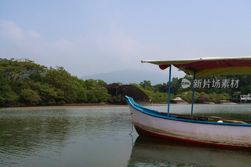 近距离图像系泊，平底船撑船在回水泻湖浅滩，热带岛屿天堂沙滩，海水的边缘，林地的观点，重点在前景