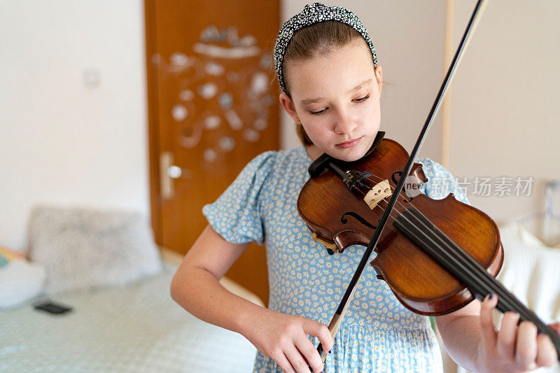 十几岁的女孩在家里拉小提琴
