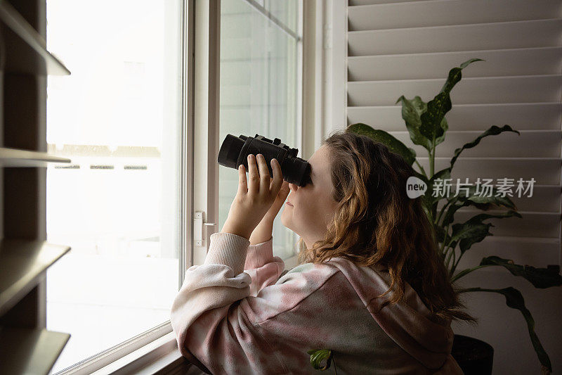 女孩用望远镜看窗外