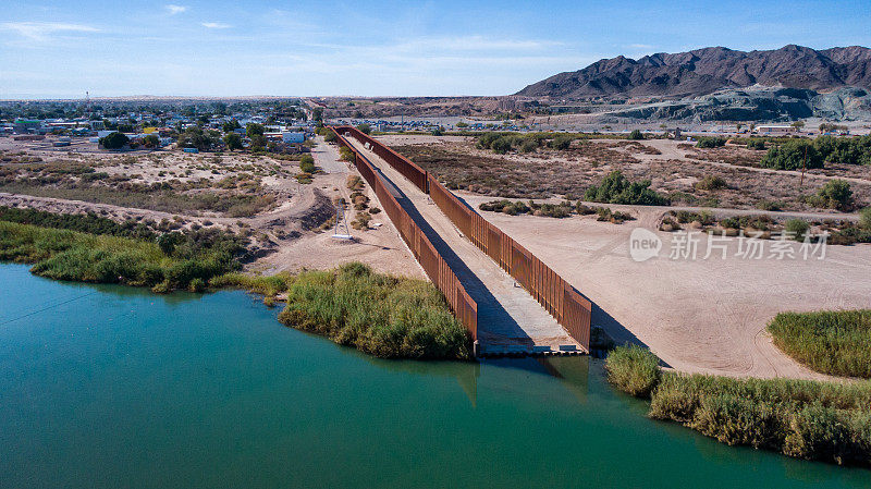 在阳光明媚的一天，亚利桑那州尤马和北墨西哥下加利福尼亚州阿尔戈多内斯之间的鸟瞰图无人机边界墙