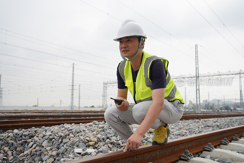 年轻的铁路工人正在检查铁轨