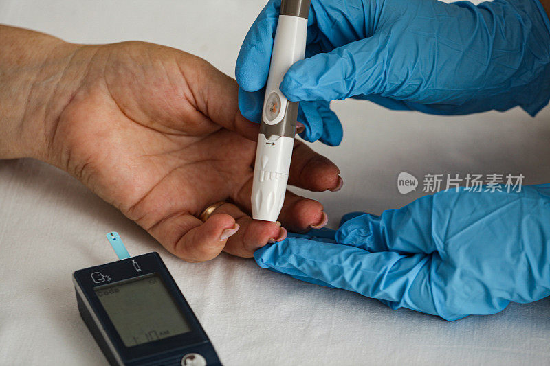 医生在诊所测量糖尿病患者的血糖水平
