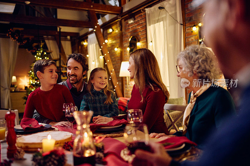 快乐的多代家庭团聚在餐桌上享受圣诞晚餐。