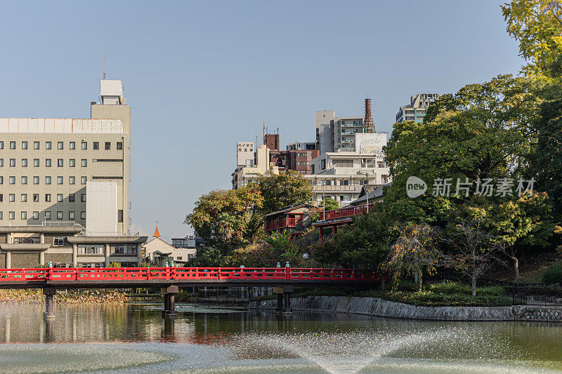 秋天，日本大阪天王寺公园里美丽的湖底池、红木桥和川池